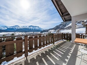 Ein Balkon mit Blick auf schneebedeckte Berge und einen klaren Himmel.