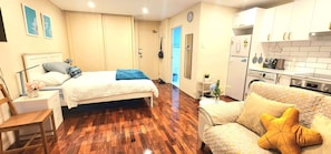 Une chambre d’hôtel comprenant un lit, un canapé, un bureau, une chaise, une armoire, une salle de bain et une kitchenette.