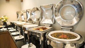 Montaje de bufé con varios recipientes de comida y utensilios para servir.