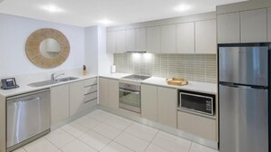 Uma cozinha moderna com eletrodomésticos de aço inoxidável, forno embutido e micro-ondas.