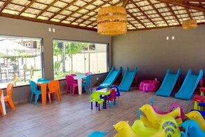 A children's play area with tables, chairs, and slides. - Porto Mar Hotel Porto Seguro (Porto Seguro)