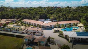 Ein Resort mit mehreren Gebäuden, einem Swimmingpool und einer üppigen Grünanlage.