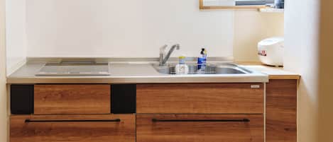 A kitchen with a double sink, wooden cabinets, and a built-in dishwasher.