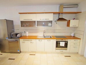 A compact kitchen with a microwave, oven, sink, and cabinets. - Holiday apartment Lana, Banjole by Interhome (Pula/Banjole)