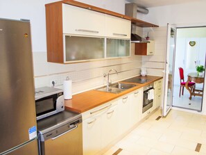 Eine Küche mit Kühlschrank, Mikrowelle, Spüle und Schränken.