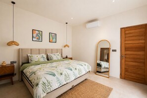 A bedroom with a bed, bedside tables, a mirror, and a wardrobe.