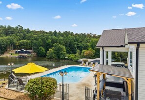 A swimming pool with a deck, lounge chairs, and a yellow umbrella. - Lakefront 7BR, 7BA Retreat with Pool, Hot tub, Game room, and Private dock. (Hot Springs)