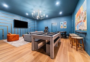 A room with a pool table, a sofa, a television, and a door. - Lakefront 7BR, 7BA Retreat with Pool, Hot tub, Game room, and Private dock. (Hot Springs)