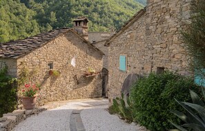 Ein Steinhaus mit einem Kiesweg, der zu einem schmalen Eingang führt.