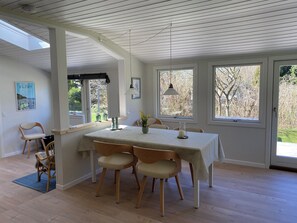Ein Essbereich mit Tisch, Stühlen und Blick ins Freie.
