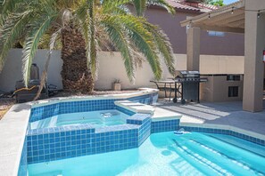 A swimming pool with blue tiles, a hot tub, a grill, and a palm tree. - Serene 5-bedrooms 3 bathrooms House with Pool in North Las Vegas (North Las Vegas)