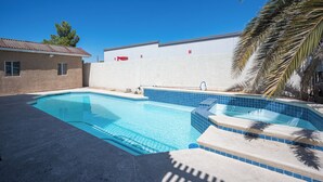 A swimming pool with clear blue water, surrounded by a white wall and a concrete deck. - Serene 5-bedrooms 3 bathrooms House with Pool in North Las Vegas (North Las Vegas)