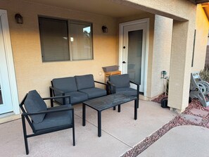 Une terrasse avec un canapé, des chaises et une table.
