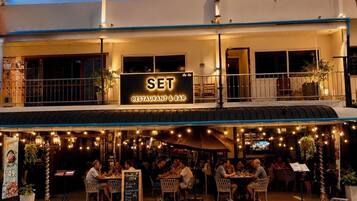 Een restaurant met terras, een bord waarop 'SET RESTAURANT & BAR' staat, en een menukaart.