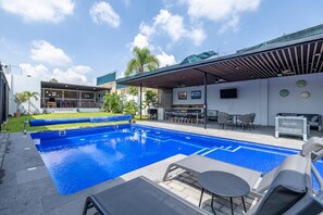 A swimming pool with lounge chairs and a covered seating area. - Country house with a heated pool, terrace, and garden, accommodating up to 22 people (Jalisco)