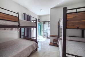 A room with bunk beds, a small table, and a view of a balcony. - Country house with a heated pool, terrace, and garden, accommodating up to 22 people (Jalisco)