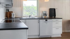 Eine moderne Küche mit Geschirrspüler, Kaffeemaschine und Toaster auf der Arbeitsfläche.