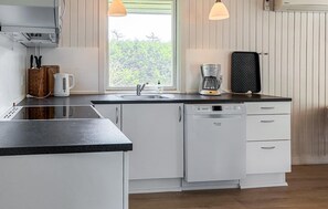 Eine moderne Küche mit Geschirrspüler, Kaffeemaschine und Toaster auf der Arbeitsfläche.