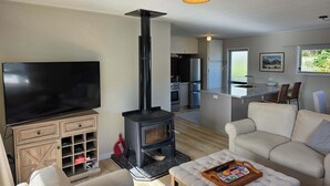 A modern living room with a television, sofa, and a fireplace. - Comfy Haven in the Heart of Picton (Picton)