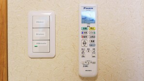 A wall-mounted thermostat and control panel with multiple settings and buttons.