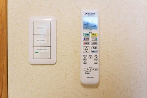 A wall-mounted thermostat and control panel with multiple settings and buttons.