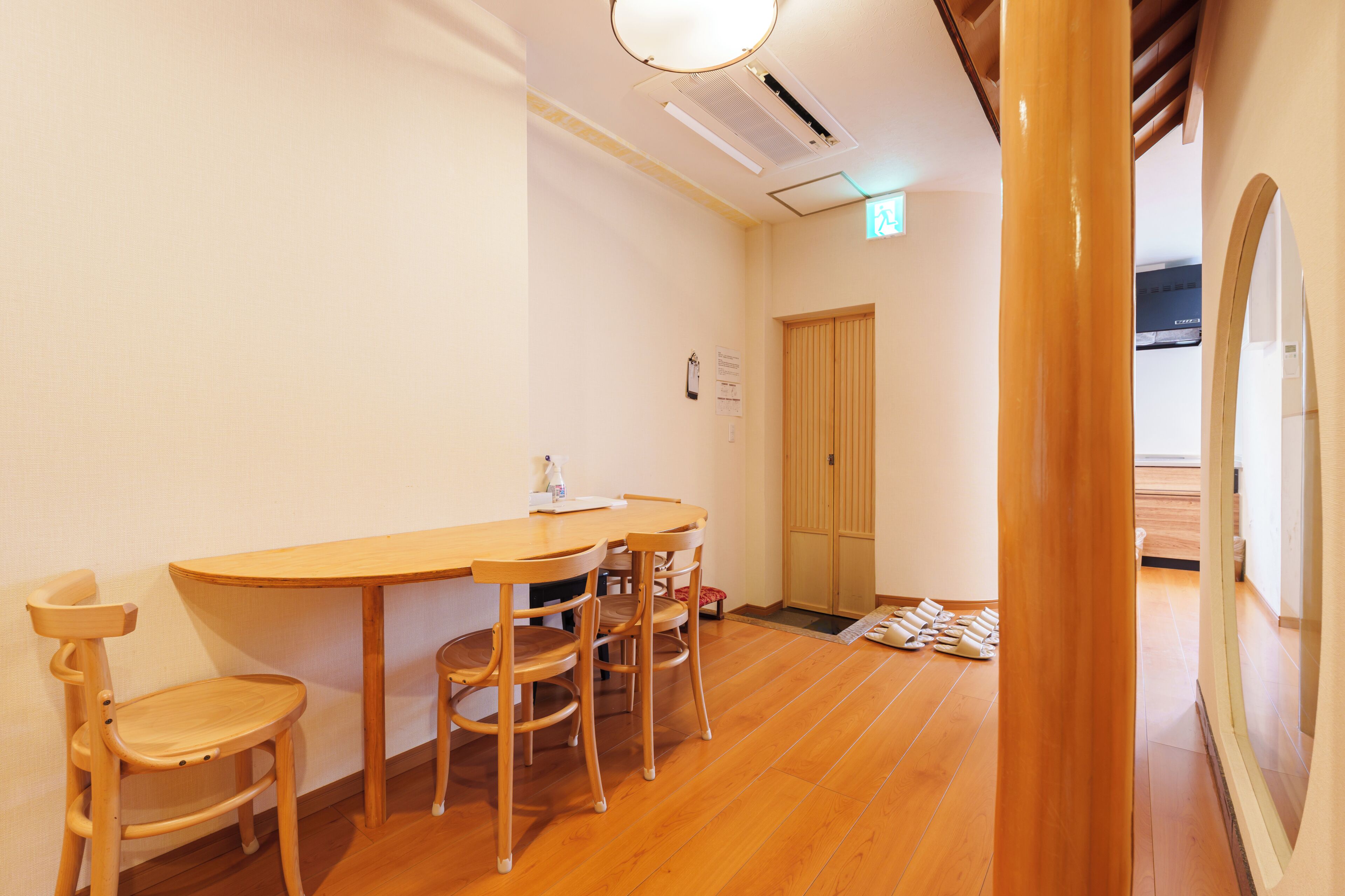 A room with a wooden table and chairs, a door, and a tiled floor.