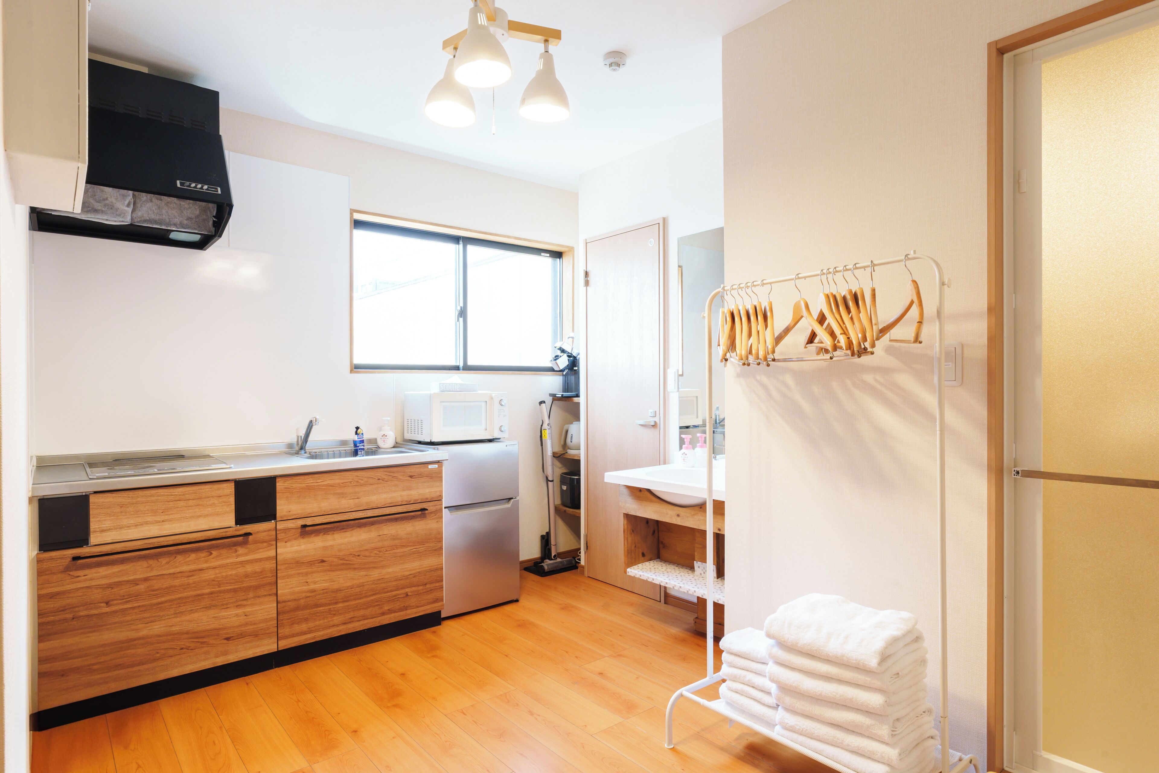 A modern kitchen with wooden cabinets, a built-in microwave, and a stainless steel refrigerator.