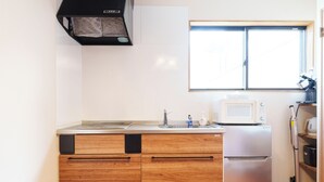 A compact kitchen with a microwave, a sink, and wooden cabinets.
