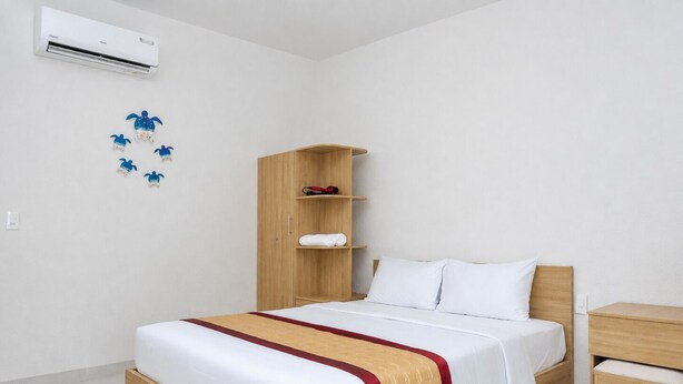 Une chambre d’hôtel avec un lit en bois, une table de chevet en bois, une armoire et un climatiseur fixé au mur.
