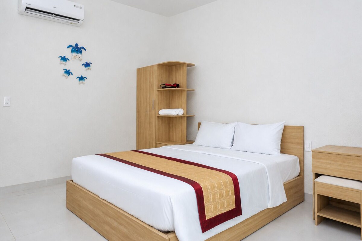 A hotel room with a wooden bed, a wooden nightstand, a wardrobe, and a wall-mounted air conditioner.