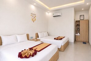A hotel room with two beds, a wardrobe, an air conditioning unit, and a decorative hanging ornament. - Gem's House (Mui Ne)