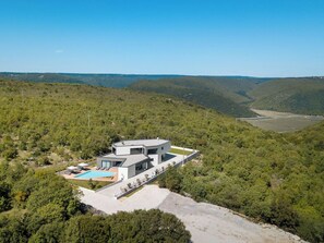 A modern two-story house with a swimming pool, surrounded by forested hills. - Villa H2 by Interhome (Labin)