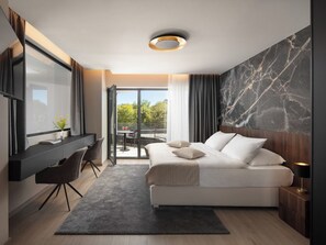 Een moderne slaapkamer met een groot bed, een bureau en uitzicht op het omliggende landschap.
