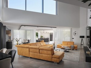 A spacious living area with a large sectional sofa, a dining table, and a kitchen in the background. - Villa H2 by Interhome (Labin)