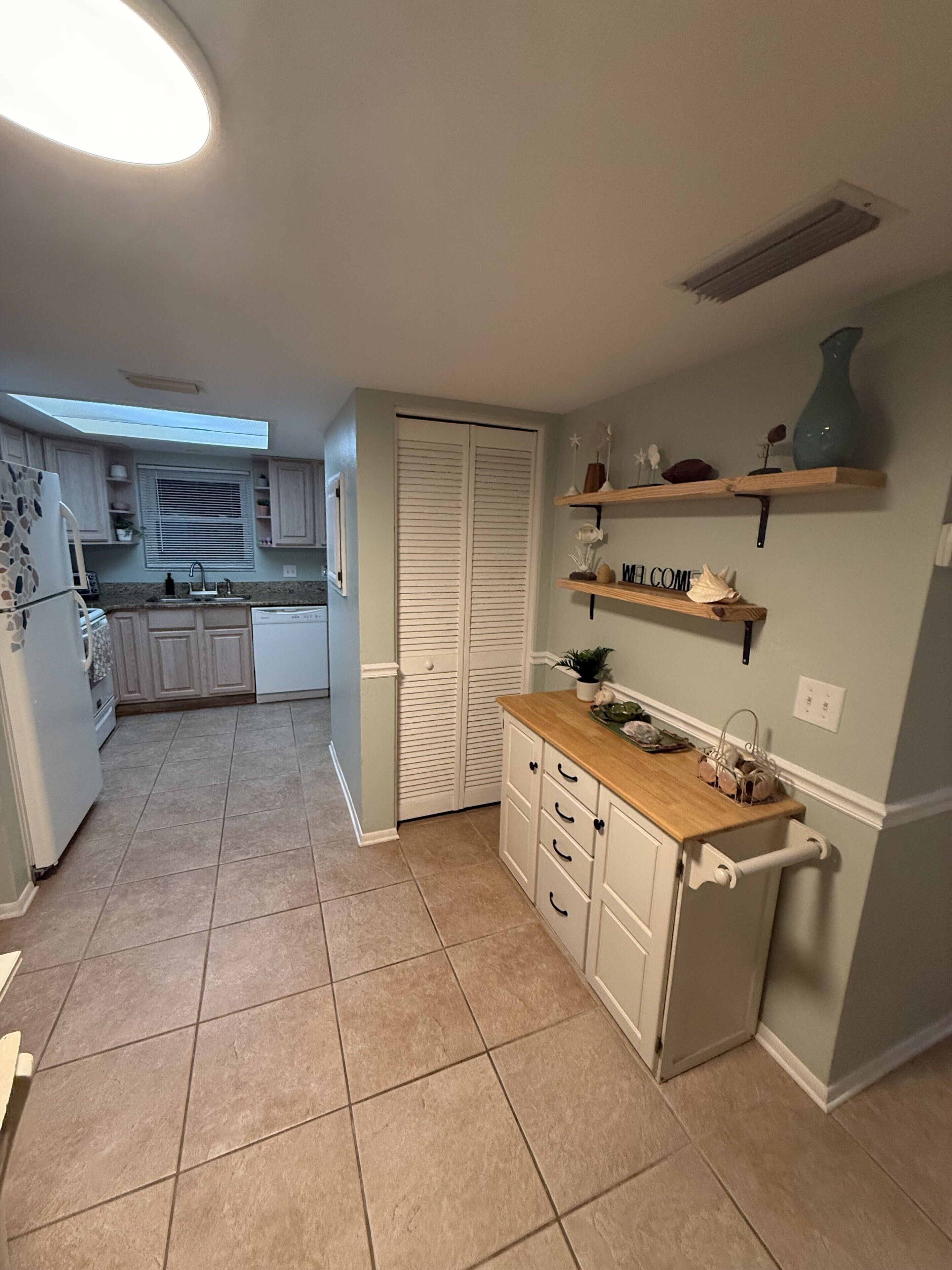 A compact kitchen with a built-in oven, a sink, and a window above the countertop.