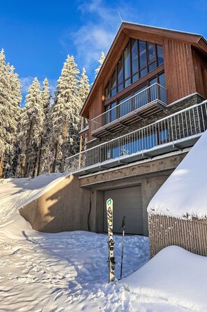 A wooden chalet with a balcony, surrounded by snow-covered trees. - Rebelka by Interhome (Horni Misecky)