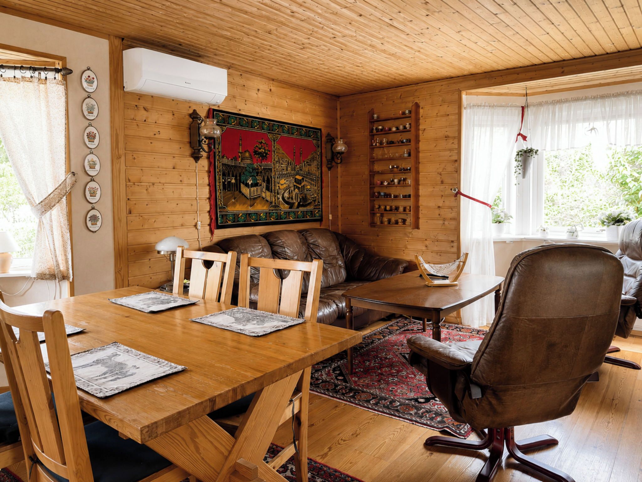 A cozy wooden interior with a dining table, chairs, a sofa, and a large decorative painting.