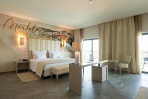 A hotel room with a bed, bedside table, lamp, and a mural on the wall. - Vila Gale Collection Monte do Vilar (Beja)