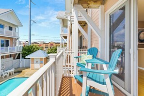 A balcony with a pool, a small shed, and a view of neighboring buildings. - Oceanside,Pool,Skee-ball,Nintendo,Pets,Arcades (Ocean City)