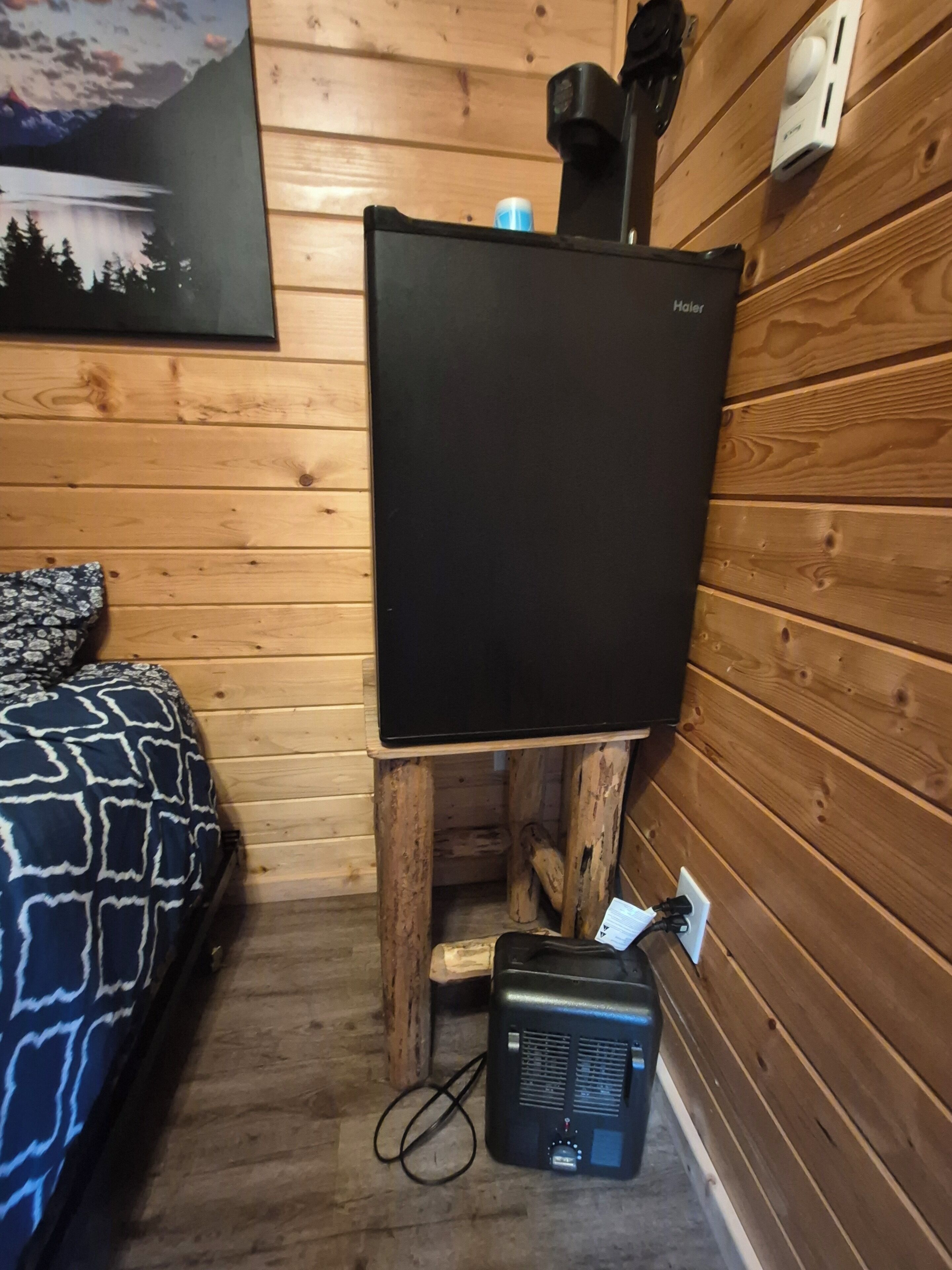 A room with a bed, a television, and a heater.