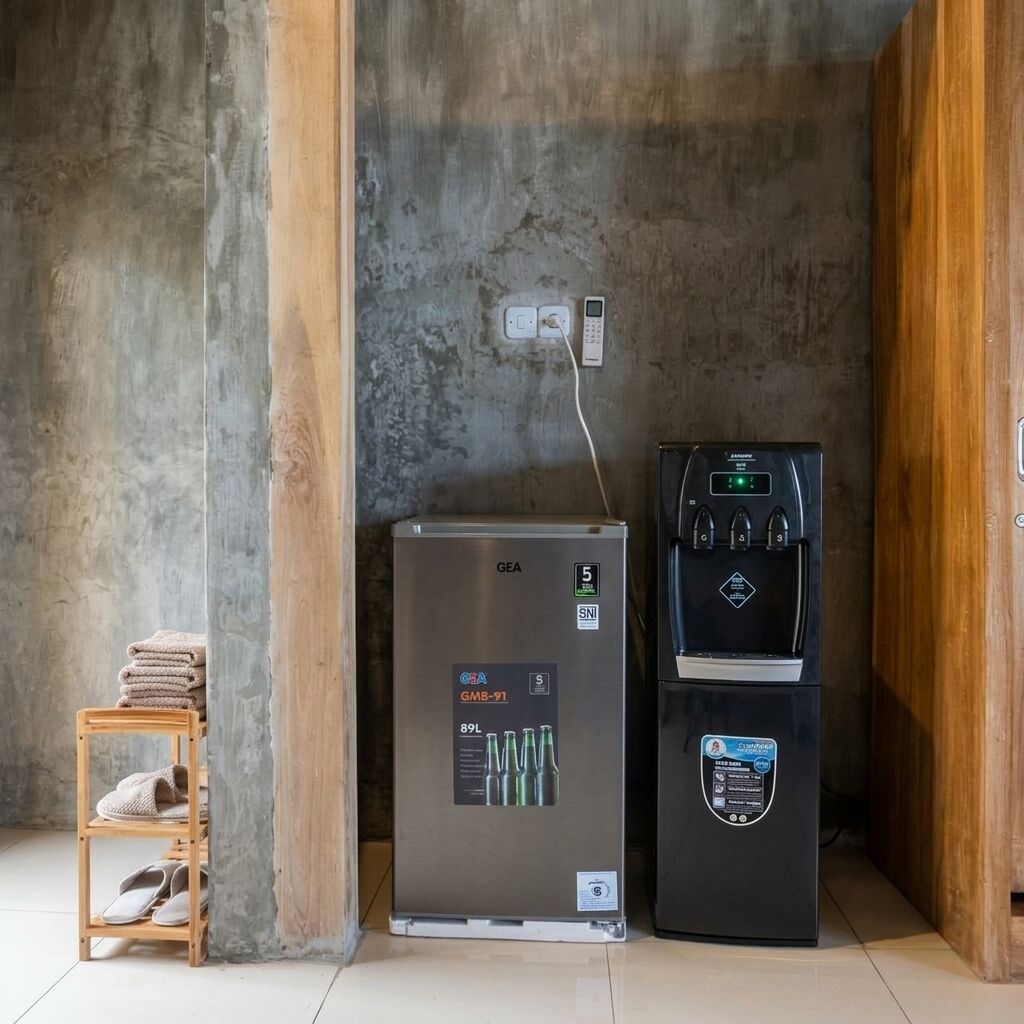 A GEA refrigerator and a water dispenser in a room with a concrete wall and wooden paneling.