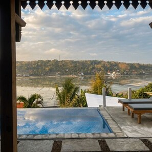Una piscina con vistas a un río y colinas.