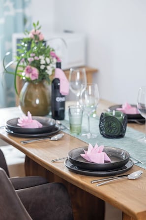 A dining table set with plates, cutlery, and a vase of flowers. - Eberharter am Schweinberg by Interhome (Mayrhofen)