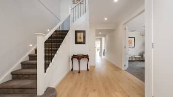 A staircase with a handrail, a wooden table, and a framed picture on the wall.