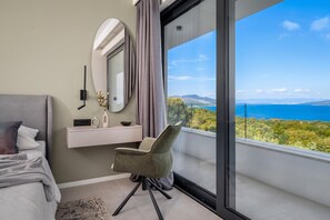 A modern bedroom with a large window, a bedside table, a chair, and a bed. - Villa Alba (Rasa)