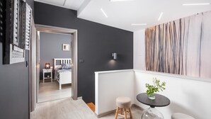 A modern interior with a hallway leading to a bedroom, a round table with a vase, and a painting on the wall. - Villa Terra With Pool & Sauna Near Rabac (Labin)