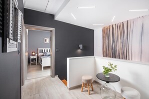 A modern interior with a hallway leading to a bedroom, a round table with a vase, and a painting on the wall. - Villa Terra With Pool & Sauna Near Rabac (Labin)