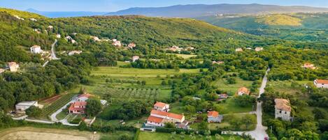 A rural landscape with scattered houses, fields, and a road.