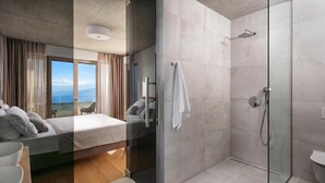 A modern hotel room with a bed, a shower, and a view of the sea. - Villa Saturea With Pool & Sauna Near Rabac (Labin)