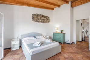 Un dormitorio con cama, mesitas de noche, cómoda y un adorno en la pared.